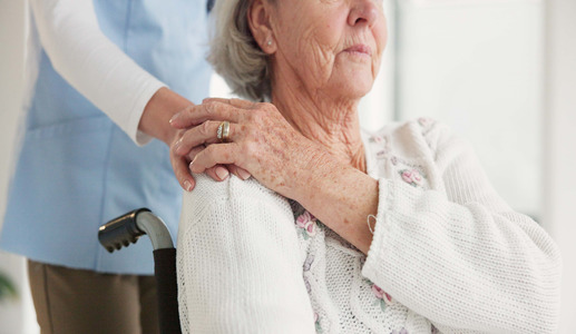 Caregiver's hand on senior's shoulder.